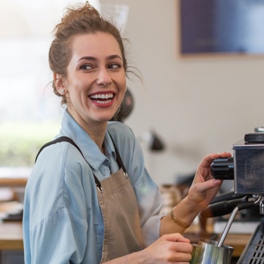 Smiling barista in overalls